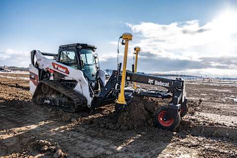 A Bobcat T86 Compact Track Loader, Equipped With Laser-Guided Grader Attachment, Grades Material on a Jobsite Under Development