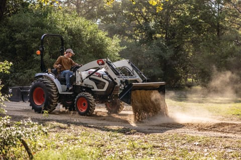 A Bobcat CT2025 Compact Tractor Dumps Dirt Using Its Bucket