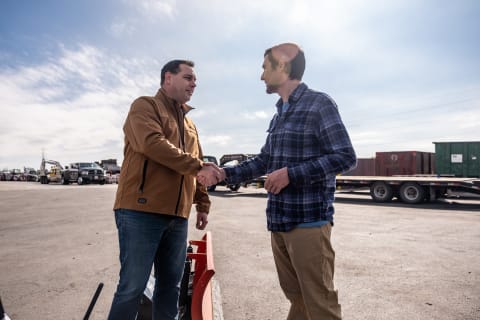 A Bobcat Dealership Employee Shakes Hands With a Customer on the Equipment Lot