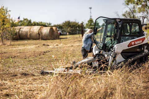 Carla Beltran Climbs Into Her Bobcat T66 Compact Track Loader Equipped With a Brushcat Rotary Cutter Attachment