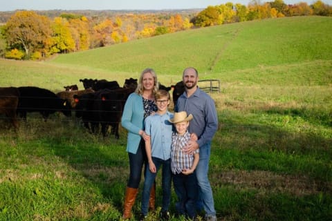 Check Family Standing in Front of Cattle on Blufftop Farm