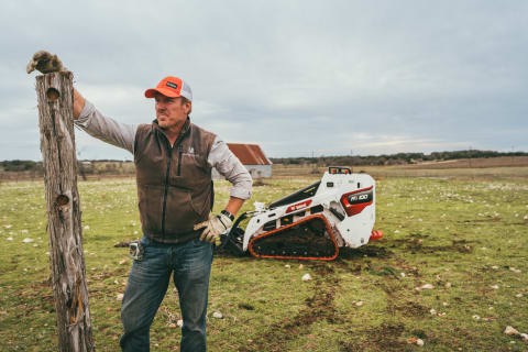 Chip Gaines standing in front of a MT100 mini track loader. 