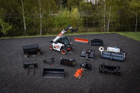 Aerial view of Bobcat's TL25.60 telehandler, showcased in a gravel lot surrounded by various attachments.