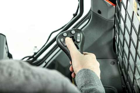 Bobcat Equipment Operator Utilizing Selectable Joystick Controls