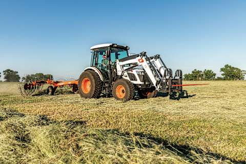 Operator Pulls a Wheel Rake in a Hay Field With a Bobcat UT6573 Utility Tractor