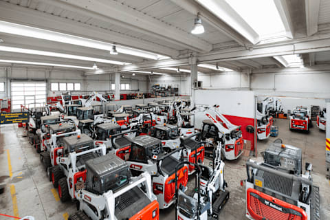 A bird's-eye view of a large garage filled with Bobcat machines.