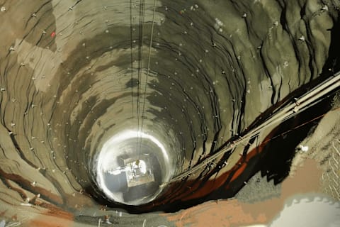 Night shot of the Bobcat E88 being hoisted up from the bottom of a shaft.