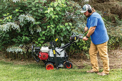 Operator uses a Bobcat SC18H sod cutter to edge along a tree bed