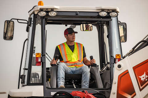 An Operator in the Cab of a Bobcat B760 Backhoe Loader 