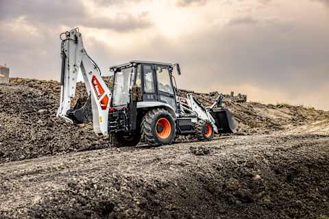 B760 Backhoe Loader Travels Across a Dirt Path