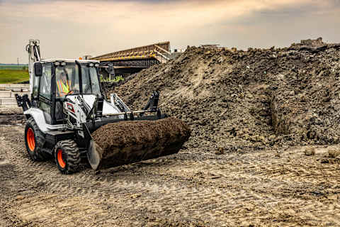 Bobcat B760 Backhoe Loader Carries Dirt Across a Jobsite