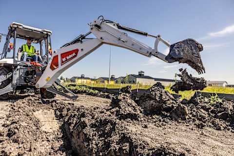 Bobcat B760 Backhoe Loader digging trench on jobsite