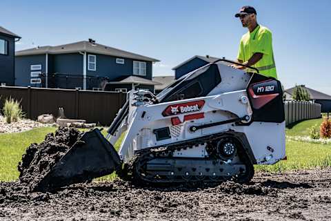 A Bobcat MT120 Mini Track Loader Moves Dirt in a Residential Yard
