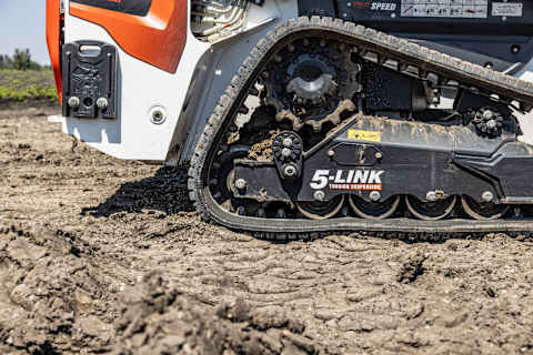 Close-up of Bobcat loader 5-Link torsion suspension undercarriage, designed for stability, traction, and smoother ride on rough terrain.