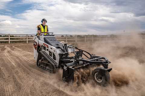  A Bobcat Mini Track Loader Operator Uses the Soil Conditioner Attachment to Break Up Soil