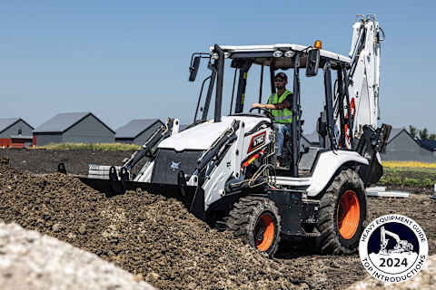 The Bobcat B760 backhoe loader scoops a pile of dirt. The image includes Heavy Equipment Guide’s 2024 Top Introductions logo in the lower righthand corner.
