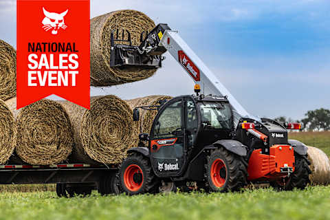 A Bobcat TL623 Telehandler With a Bale Spear Lifts a Hay Bale Onto a Truck Bed; the National Sales Event Banner Is on the Top-Left Corner