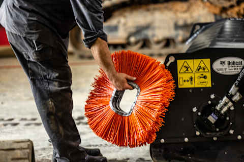 A Person Holding Orange Bobcat Bristles