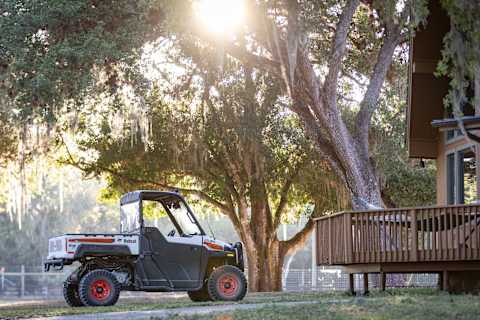 A Bobcat UV34 Utility Vehicle With the Sport Accessories Package on a Grassy Area at a Residential Property