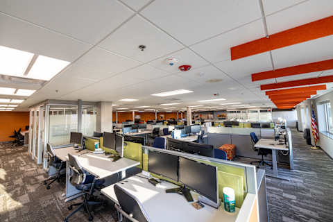 Bobcat Bismarck Manufacturing Facility open office space with desk spaces and enclaves in brand color design