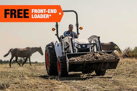 A Bobcat Compact Tractor Operator Transports a Bucketful of Dirt on a Horse Ranch; A Free-Front End Loader Banner Is Displayed in the Top-Left Corner