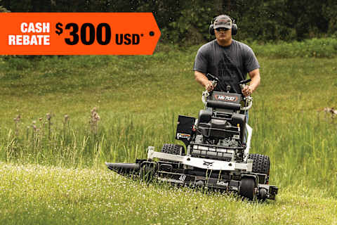 An Operator Mows a Grassy Area Using a Bobcat WB700 Walk-Behind Mower; A Cash Rebate Banner Is in the Top-Left Corner