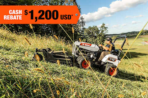 A Bobcat Articulating Tractor Clears Heavy Brush on a Steep Slope With the Rough Cut Mower Attachment; A Cash Rebate Banner Is in the Top-Left Corner 