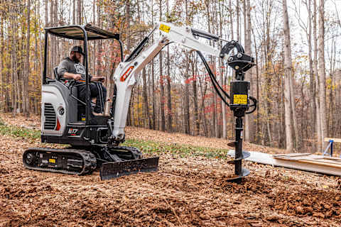 An Operator Drills a Hole Using a Bobcat Compact Excavator Equipped With an Auger Attachment