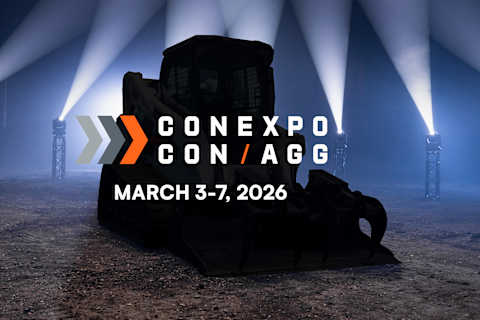 A Bobcat Compact Track Loader With a Grapple Attachment Displayed in Front of Stage Lights Promoting ConExpo Con Agg March 3-7 2026