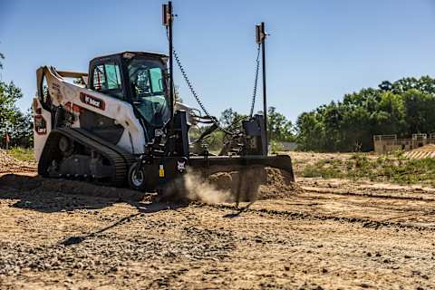Bobcat Pro T86-2 compact track loader with box blade grading dirt on a construction site