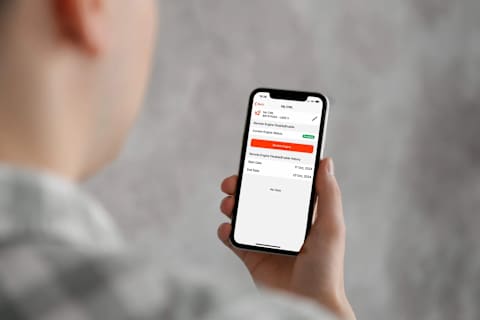 Operatore che controlla i dati della macchina nell'app mobile Bobcat Machine IQ, che mostra la posizione, le ore di funzionamento e gli intervalli di Manutenzione