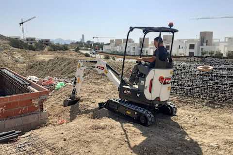 Operatore al lavoro con il Bobcat Miniescavatore E17z, posizionando il materiale di scavo accanto al rinforzo in Acciaio in cantiere