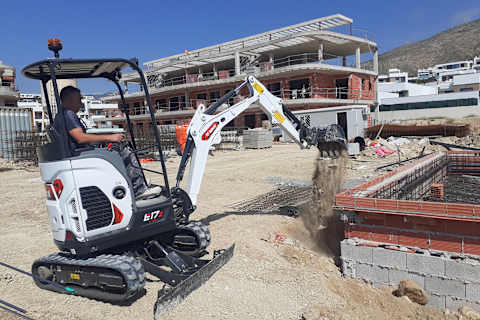 Bobcat Miniescavatore Bobcat E17z Serie R2 che scava vicino ai muri di fondazione in un cantiere urbano ristretto