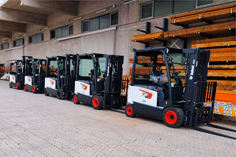 New Bobcat B25X-7 Plus electric forklifts delivered by dealer La Nordica Macchine lined up outside a warehouse