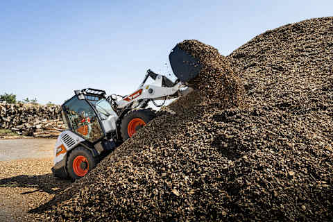 Une photo en action de la chargeuse sur pneus compacte L100 de Bobcat