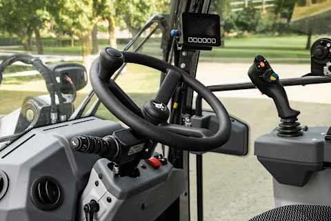 
Photo en action de la chargeuse articulée sur pneus Bobcat L85 et d’un opérateur transportant des poteaux métalliques.