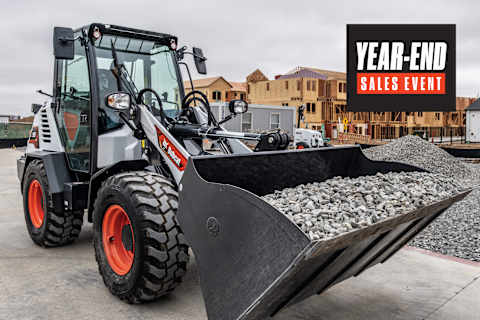 Bobcat L95 Compact Wheel Loader With Bucket Attachment Carrying Gravel at a Residential Construction Site With a Year-End Sales Event Badge