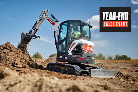 Bobcat E35 Compact Excavator With Bucket Attachment Digging and Moving Soil at an Outdoor Worksite With a Year-End Sales Badge