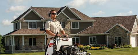 Commercial operator mowing large residential property with Bobcat ZS4000 zero-turn stand-on mower