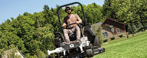 Commercial landscaper mowing alongside building of large acreage property with the Bobcat ZT6100 zero-turn riding mower