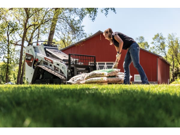 Homeowner loading bags of mulch with a Bobcat MT100 pallet fork attachment