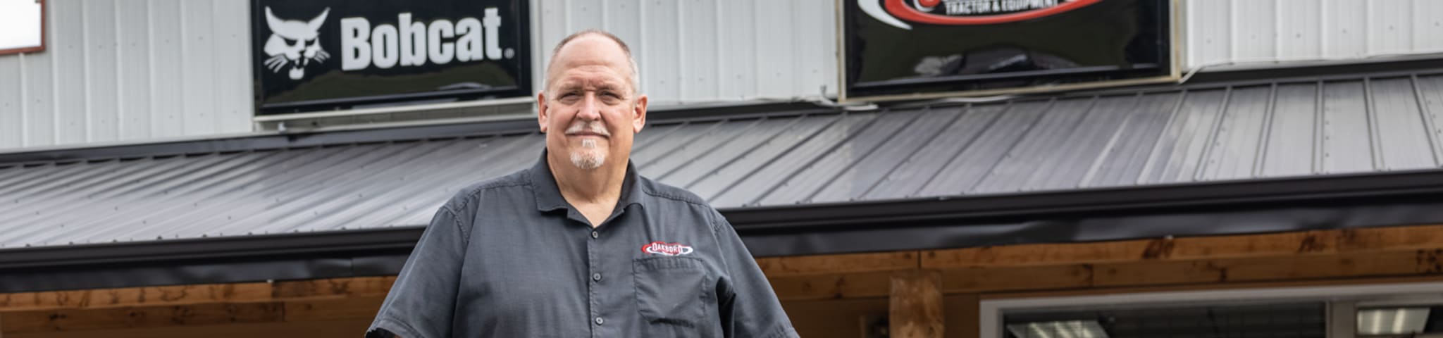 Bobcat Dealer Standing In Front Of Dealership