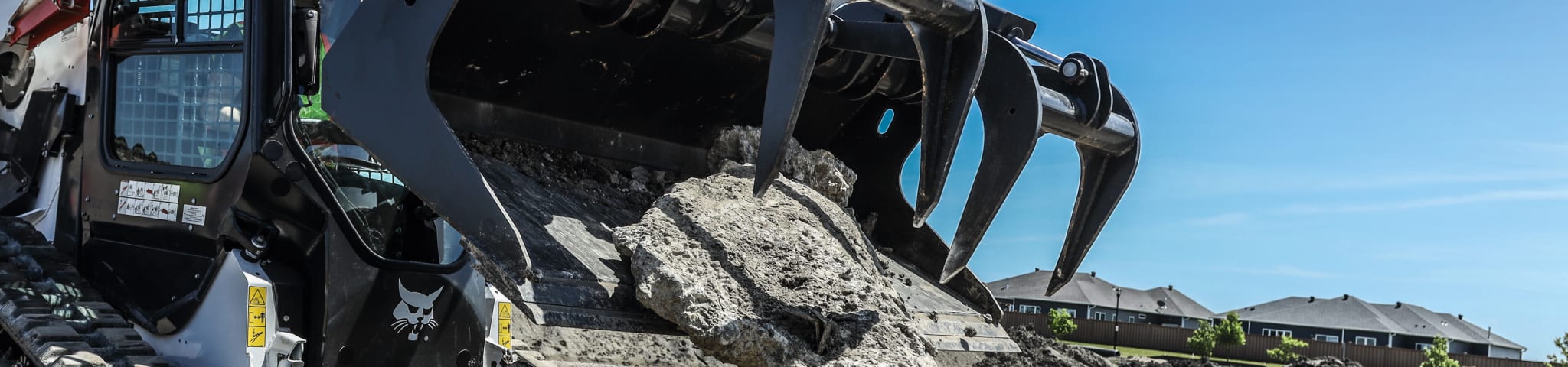 A Bobcat T62 Compact Track Loader Lifts a Large Chunk of Concrete with the Industrial Grapple Attachment