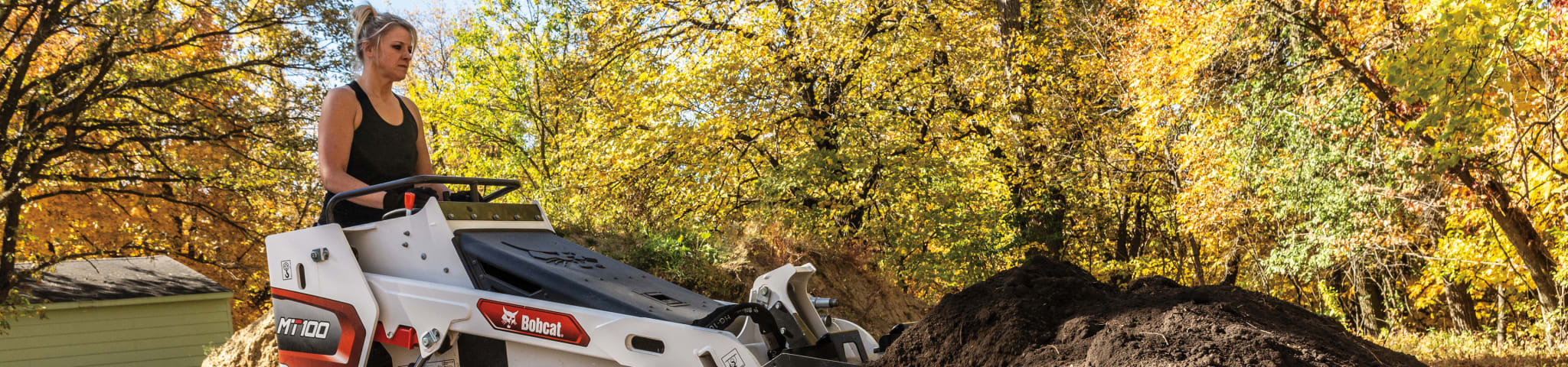 A Bobcat MT100 Mini Track Loader Moves Dirt Using Its Bucket