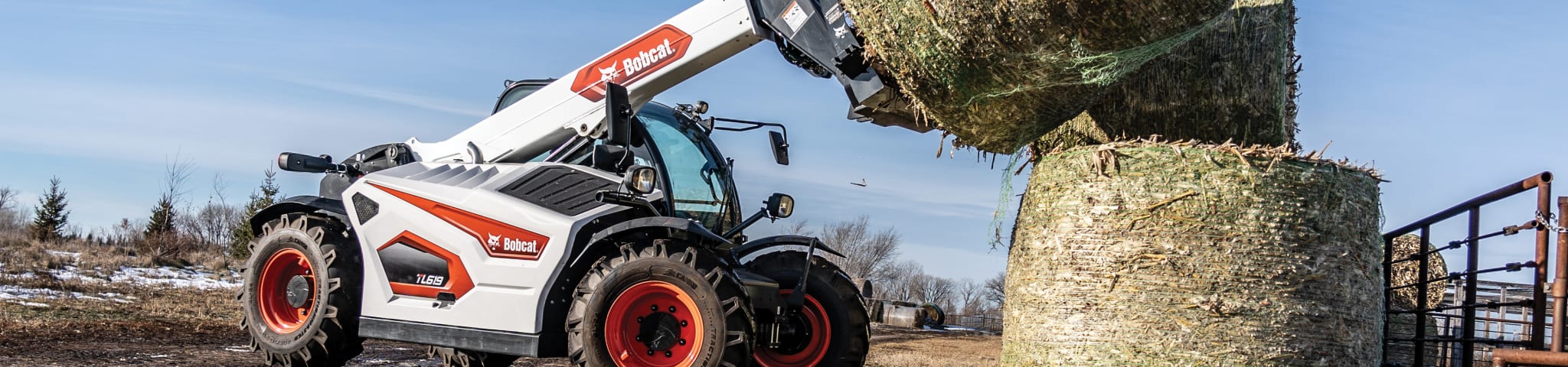 A Bobcat TL619 Telehandler Lifting a Hay Bale