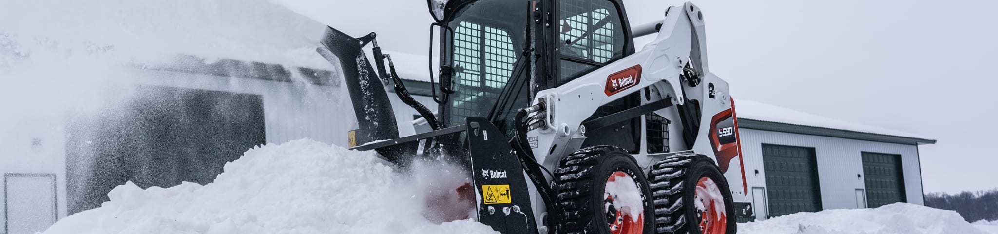 A Bobcat Skid-Steer Loader Clears Snow with the Snowblower Attachment