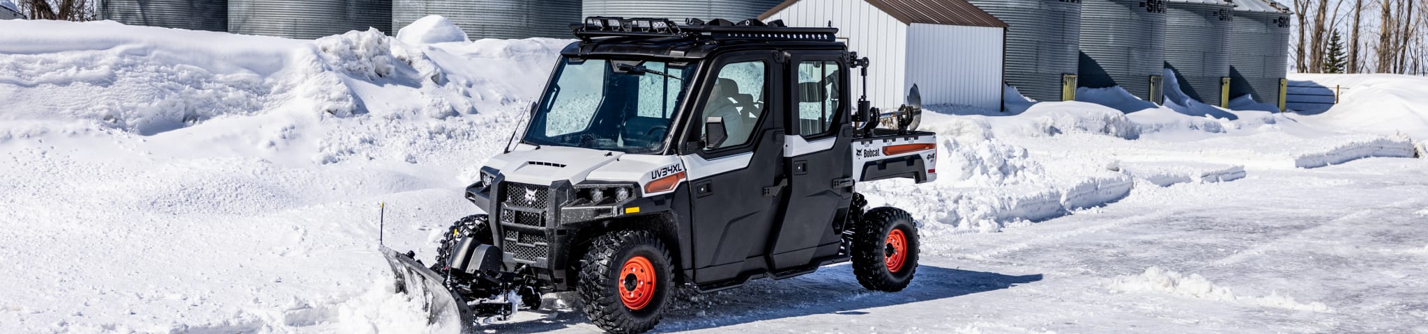 A Bobcat UV34XL Utility Vehicle Pushing Snow With the Snow Blade Accessory 