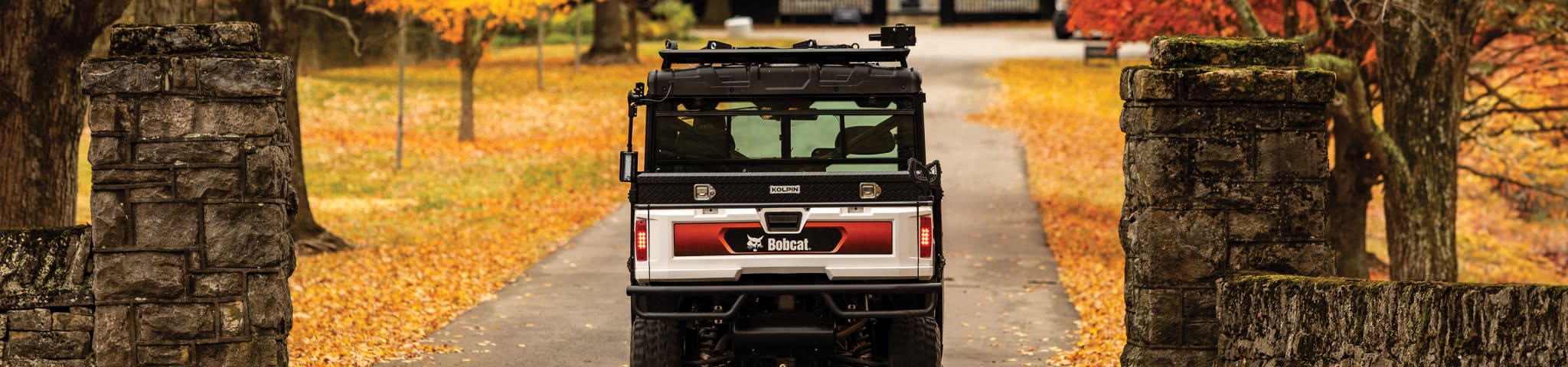 A Bobcat UV34XL Utility Vehicle Travels on a Gated Pathway