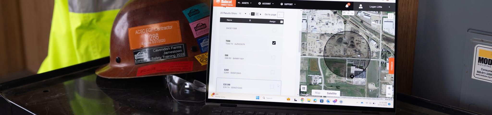 A Laptop Showing Machine IQ Sits Next to a Hard Hat and Work Glasses on a Desk