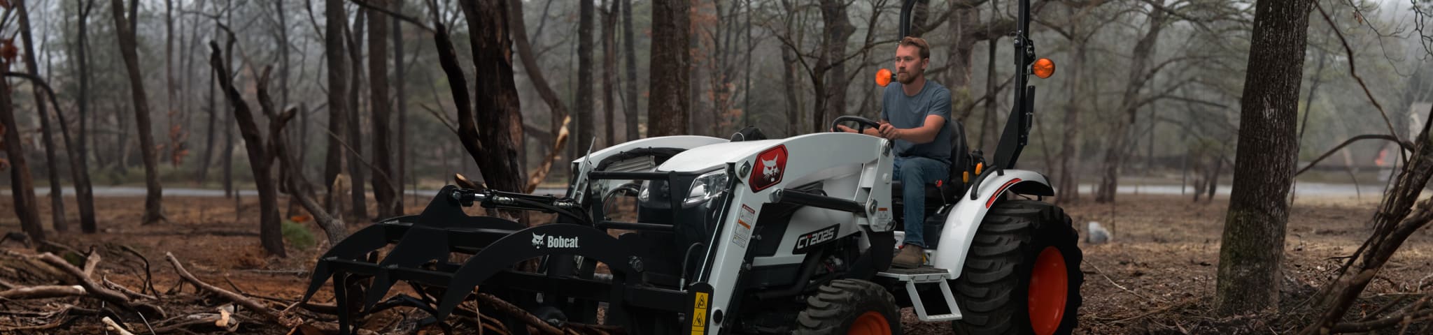 Operator Uses a Bobcat CT2025 Compact Tractor With Brush Grapple Attachment to Pick Up Fallen Trees